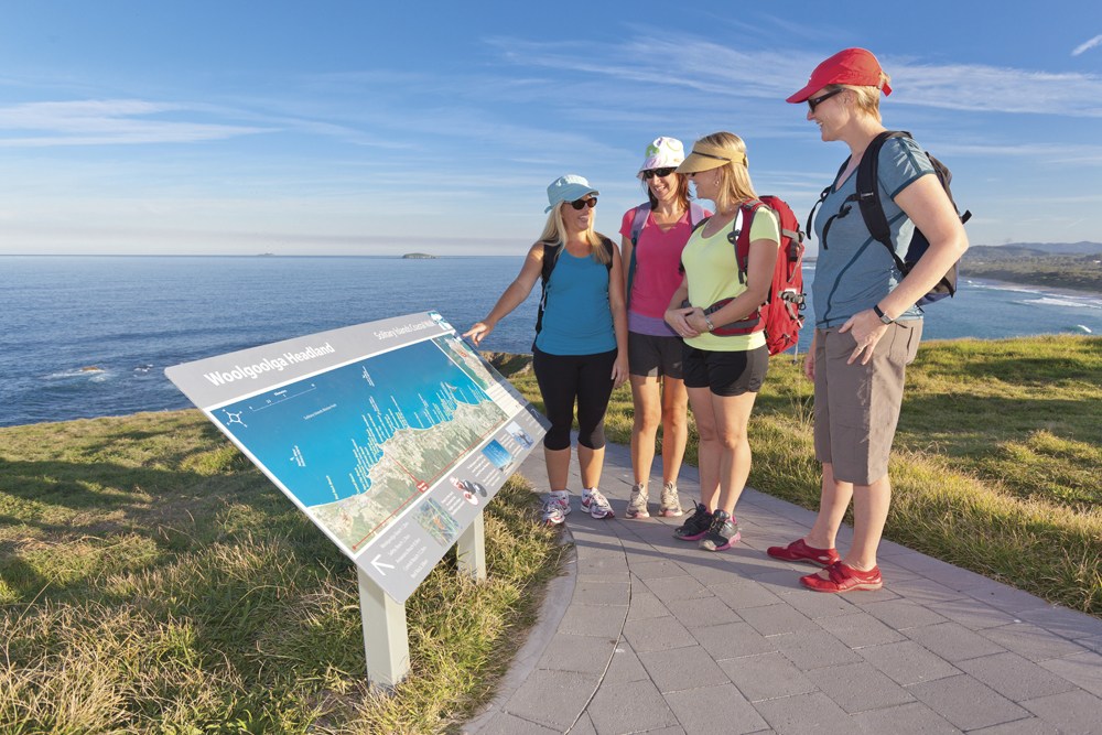 Solitary Islands Coastal Walk. Shows walkers gathered around sign along the coastal walking path in Woolgoolga.